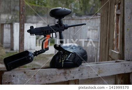 A military pistol on a wooden barrier, resting on a protective helmet A military pistol on a wooden barrier, resting on a protective helmet 141999370