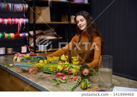 Dedicated flower artisan designs colorful bouquets diligently within cozy studio Dedicated flower artisan designs colorful bouquets diligently within cozy studio 141999468