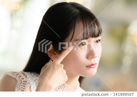 一位女士用手指檢查眼睛。 141999507