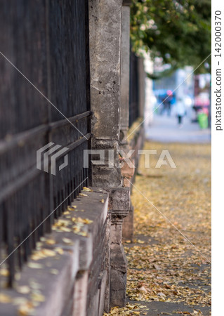 Autumn sidewalk beside old wooden fence Autumn sidewalk beside old wooden fence 142000370