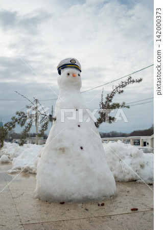 Snowman with captain hat on a cloudy winter day 142000373