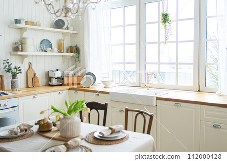 Scandinavian classic minimalistic kitchen with white and wooden details flowers. Modern white kitchen clean contemporary style interior design. Empty bright white interior minimal of kitchen Scandinavian classic minimalistic kitchen with white and wooden details flowers. Modern white kitchen clean contemporary style interior design. Empty bright white interior minimal of kitchen 142000428