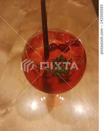 Refreshing red cocktail with cranberries and thyme, serving as a bright, cooling beverage for social gatherings, parties, or a relaxing evening drink Refreshing red cocktail with cranberries and thyme, serving as a bright, cooling beverage for social gatherings, parties, or a relaxing evening drink 142000885