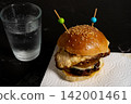 Gourmet breakfast burger with fried egg and caramelized onions on sesame brioche bun 142001461
