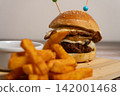 Gourmet Cheeseburger with Fried Egg and French Fries on Wooden Board 142001468