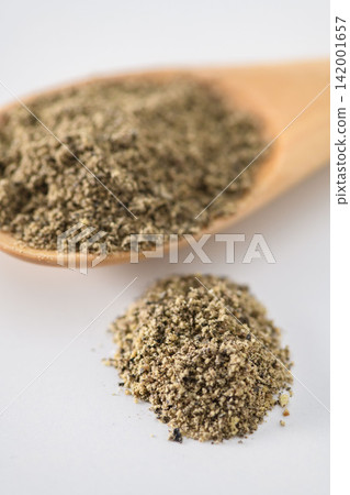 Ground black pepper powder served in a wooden spoon Ground black pepper powder served in a wooden spoon 142001657