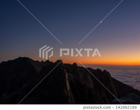 Autumn in the Hotaka mountain range, a thin crescent moon floating above the sunset and sea of clouds. Autumn in the Hotaka mountain range, a thin crescent moon floating above the sunset and sea of clouds. 142002189