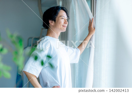 一個打開窗簾的男人 142002413