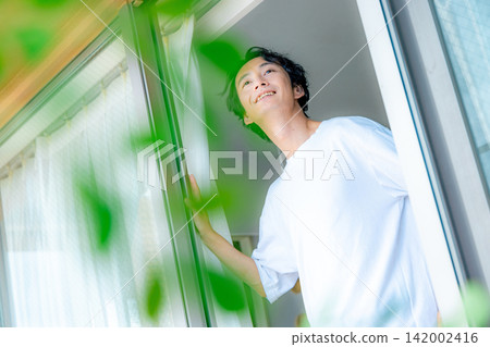 一個年輕人正望著窗外。 142002416