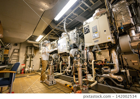 Senior female worker inspecting equipment in boiler room Senior female worker inspecting equipment in boiler room 142002534