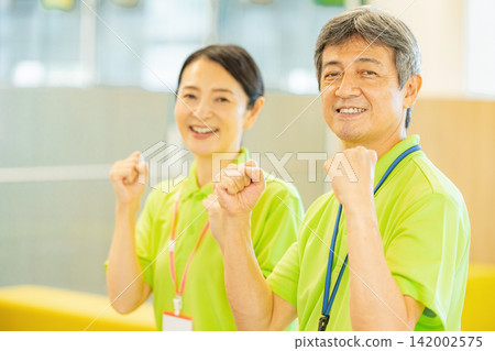 身穿polo衫的老年男女員工在一家養老院工作。 身穿polo衫的老年男女員工在一家養老院工作。 142002575