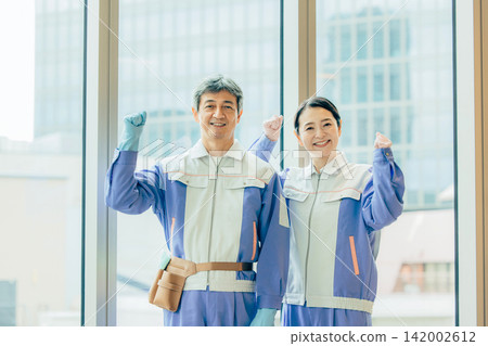 身穿清潔制服的資深男女員工站在辦公室。 142002612
