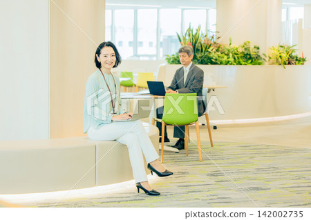 A businesswoman in her 50s working in a co-working space. A businesswoman in her 50s working in a co-working space. 142002735