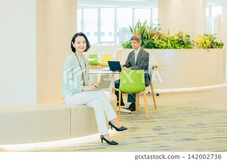 A businesswoman in her 50s working in a co-working space. A businesswoman in her 50s working in a co-working space. 142002736