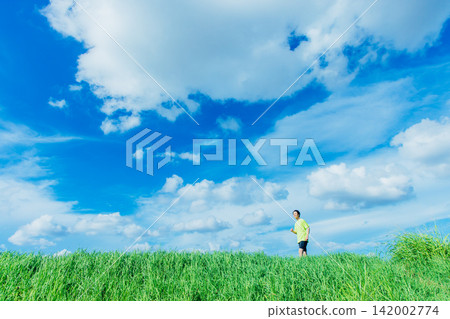 A man running against a blue sky A man running against a blue sky 142002774