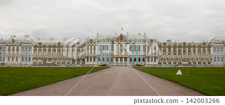 Exterior view of Catherine Palace featuring ornate architecture and well-maintained gardens, set against a cloudy sky in Tsarskoye Selo Exterior view of Catherine Palace featuring ornate architecture and well-maintained gardens, set against a cloudy sky in Tsarskoye Selo 142003266
