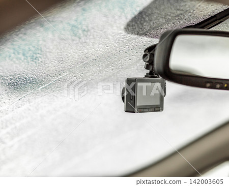 Dashboard camera is mounted on the windshield of a car, with condensation on the glass creating a blurred view of the interior Dashboard camera is mounted on the windshield of a car, with condensation on the glass creating a blurred view of the interior 142003605