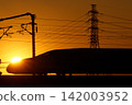 Shinkansen bullet train illuminated by the setting sun 142003952