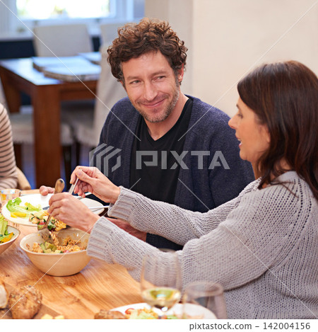 Couple, food and salad on table in house for healthy diet, dinner together and hungry for eating. Happy man, smile and meal hosting in home with woman giving for weekend lunch, plate and nutrition Couple, food and salad on table in house for healthy diet, dinner together and hungry for eating. Happy man, smile and meal hosting in home with woman giving for weekend lunch, plate and nutrition 142004156