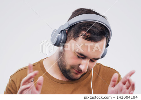 Headphones, dancing or man streaming music in studio for wellness on grey background to relax. Model, podcast or calm person listening to radio playlist, sound or song audio on an online subscription 142004194