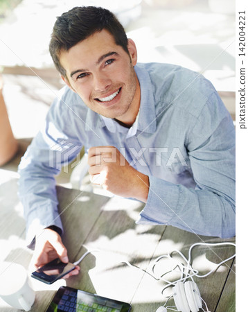 Smile, table and portrait of man with phone for online networking, communication and social media. Happy, male person and high angle with technology in garden for website, streaming and information 142004221