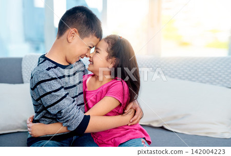 Young, kids and happy with hugging, smile and joy in family home as children in youth. Siblings, cute and cuddle as brother and sister on couch for affection, love and childhood with noses touching Young, kids and happy with hugging, smile and joy in family home as children in youth. Siblings, cute and cuddle as brother and sister on couch for affection, love and childhood with noses touching 142004223