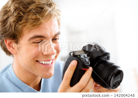 Man, camera and artist for photo hobby, home and photography for picture or digital image. Male person, equipment and confident for creative career or journalist, capture memories and shooting smile Man, camera and artist for photo hobby, home and photography for picture or digital image. Male person, equipment and confident for creative career or journalist, capture memories and shooting smile 142004248