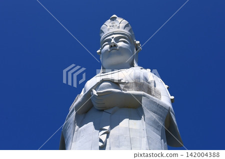 A bust of the Tokyo Bay Kannon statue, seen against a blue sky. A bust of the Tokyo Bay Kannon statue, seen against a blue sky. 142004388