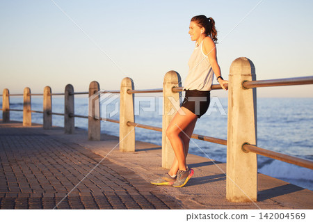 Fitness, break and thinking by woman by ocean, nature and cardio for health. Music, audio and podcast for wellness and marathon endurance sport training, female athlete and relax for workout Fitness, break and thinking by woman by ocean, nature and cardio for health. Music, audio and podcast for wellness and marathon endurance sport training, female athlete and relax for workout 142004569