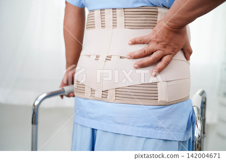 Asian senior pain back wearing elastic support belt with walker. Asian senior pain back wearing elastic support belt with walker. 142004671