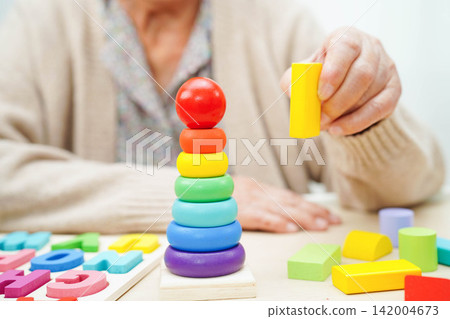 Asian elderly woman playing game. 142004673
