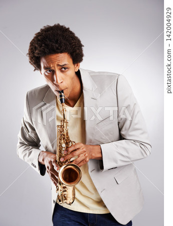 Happy, african man and music, playing the saxophone with casual outfit and clothing in studio. Confident musician, jazz and instrument with trendy suit for band performance on white background Happy, african man and music, playing the saxophone with casual outfit and clothing in studio. Confident musician, jazz and instrument with trendy suit for band performance on white background 142004929