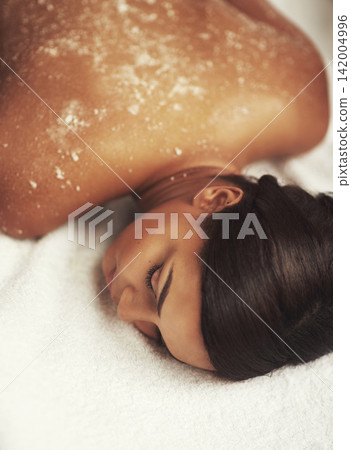 Spa, exfoliate and massage for woman, salt and relax with peace, luxury and calm in bed of resort. Wellness, comfort and relief for client, hotel and natural with treatment, pamper and rest for skin 142004996