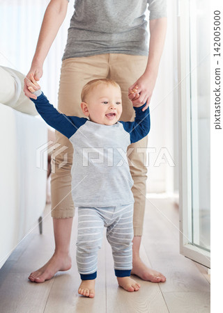 Parent, boy and baby in home, walking and learning with support, growth and development of child. House, happy and cute toddler with smile, wood and floor in apartment, steps and standing with care Parent, boy and baby in home, walking and learning with support, growth and development of child. House, happy and cute toddler with smile, wood and floor in apartment, steps and standing with care 142005000