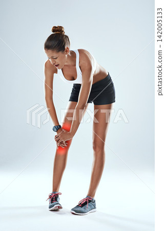 Sports injury, woman and knee with red glow for fitness, workout and gym in studio holding leg. Acl tear, pain and athlete with weight for training, exercise and medical emergency on gray background Sports injury, woman and knee with red glow for fitness, workout and gym in studio holding leg. Acl tear, pain and athlete with weight for training, exercise and medical emergency on gray background 142005133