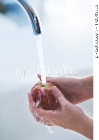 Water splash, hands and person cleaning apple, hygiene in kitchen with sustainability and disinfection, germs or bacteria. Health, wellness and nutrition with fruit, organic and fresh food at home Water splash, hands and person cleaning apple, hygiene in kitchen with sustainability and disinfection, germs or bacteria. Health, wellness and nutrition with fruit, organic and fresh food at home 142005518