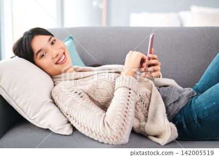Asian woman, home and smile on sofa with smartphone, text and messages with dating app and social media. Female person, internet and online for post, content update and happy with videos in portrait Asian woman, home and smile on sofa with smartphone, text and messages with dating app and social media. Female person, internet and online for post, content update and happy with videos in portrait 142005519