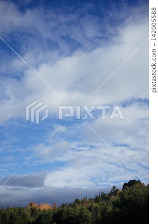秋日的山脈和飄蕩在湛藍天空中的秋雲。 秋日的山脈和飄蕩在湛藍天空中的秋雲。 142005588