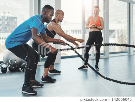 People, men and ropes for fitness in gym for workout, training and resilience for healthy lifestyle. Sports, coach and athletes exercise to target muscle, arms and shoulders with balance for strength People, men and ropes for fitness in gym for workout, training and resilience for healthy lifestyle. Sports, coach and athletes exercise to target muscle, arms and shoulders with balance for strength 142006043