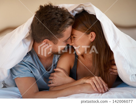 Couple, under blanket and smile or hug for support, care and in love for relationship and dating on weekend. Man, woman and happy in house for bonding, playful and romantic for honeymoon vacation Couple, under blanket and smile or hug for support, care and in love for relationship and dating on weekend. Man, woman and happy in house for bonding, playful and romantic for honeymoon vacation 142006077