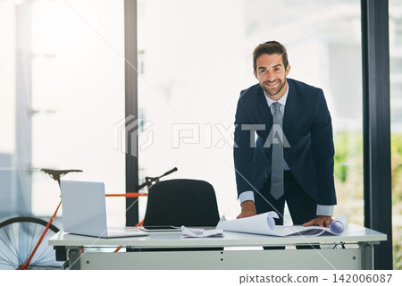 Man, architect and portrait at desk with blue print in office for project planning, designing or property. Male person, face and smile for business entrepreneur with paperwork, workplace or report 142006087