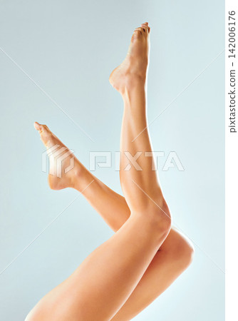 Skincare, cosmetics or legs of woman for healthy glow for hair removal or body wellness in blue background studio. Model, lady and person ready for waxing, epilation or beauty for soft or smooth feet Skincare, cosmetics or legs of woman for healthy glow for hair removal or body wellness in blue background studio. Model, lady and person ready for waxing, epilation or beauty for soft or smooth feet 142006176