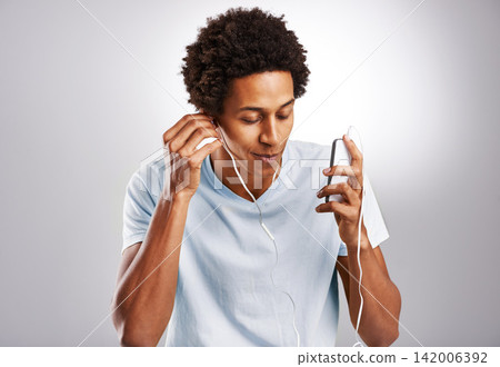 Black man, listening to music and cellphone with sound, radio and live streaming on a white studio background. African person, guy and model with smartphone and connection with digital app and audio Black man, listening to music and cellphone with sound, radio and live streaming on a white studio background. African person, guy and model with smartphone and connection with digital app and audio 142006392