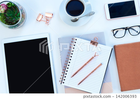 Tablet, notebook and coffee on desk with phone for working, writing notes and planning for career. Creative workplace, business and diary, digital tech and stationery on blue background for job 142006393