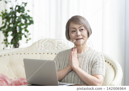 一位老年婦女在客廳使用電腦 一位老年婦女在客廳使用電腦 142006964