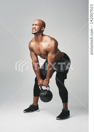 Black man, heavy and kettle bell in studio, struggle and progress for workout or training. Male person, athlete and commitment to weightlifting on gray background, tough and dumbbell challenge Black man, heavy and kettle bell in studio, struggle and progress for workout or training. Male person, athlete and commitment to weightlifting on gray background, tough and dumbbell challenge 142007023
