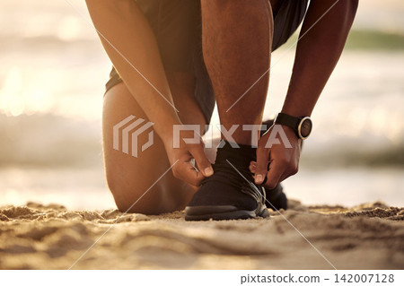 Tie, beach or hands of person with shoe lace for fitness training, exercise or running workout on sand. Runner, closeup or legs of sports athlete with footwear ready to start exercising in nature Tie, beach or hands of person with shoe lace for fitness training, exercise or running workout on sand. Runner, closeup or legs of sports athlete with footwear ready to start exercising in nature 142007128