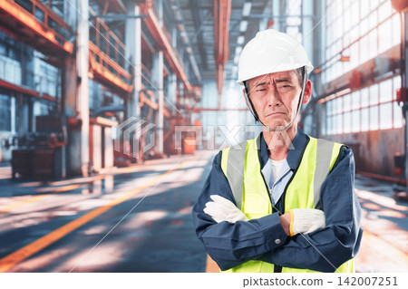工廠裡,一名男子雙手抱頭。 工廠裡,一名男子雙手抱頭。 142007251