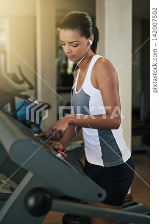 Black woman, gym and start treadmill for workout to exercise and fitness routine for health. Female person, training and music for wellness, wellbeing and self care with sportswear for hobby Black woman, gym and start treadmill for workout to exercise and fitness routine for health. Female person, training and music for wellness, wellbeing and self care with sportswear for hobby 142007502