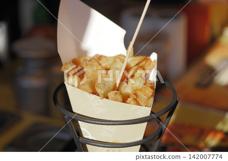 Fries in paper cone with wooden stick on display 142007774